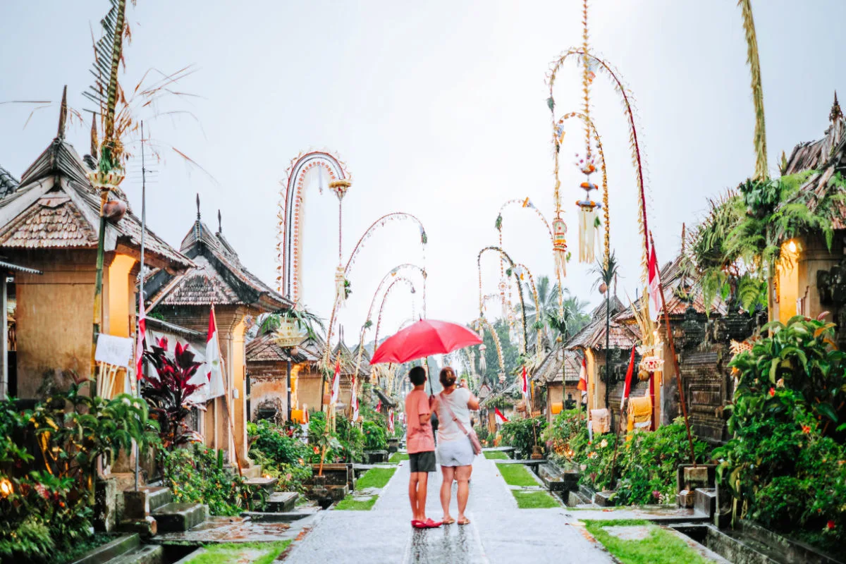 Penglipuran Village Two People Hold Umbrella in Rain in Bali.jpg