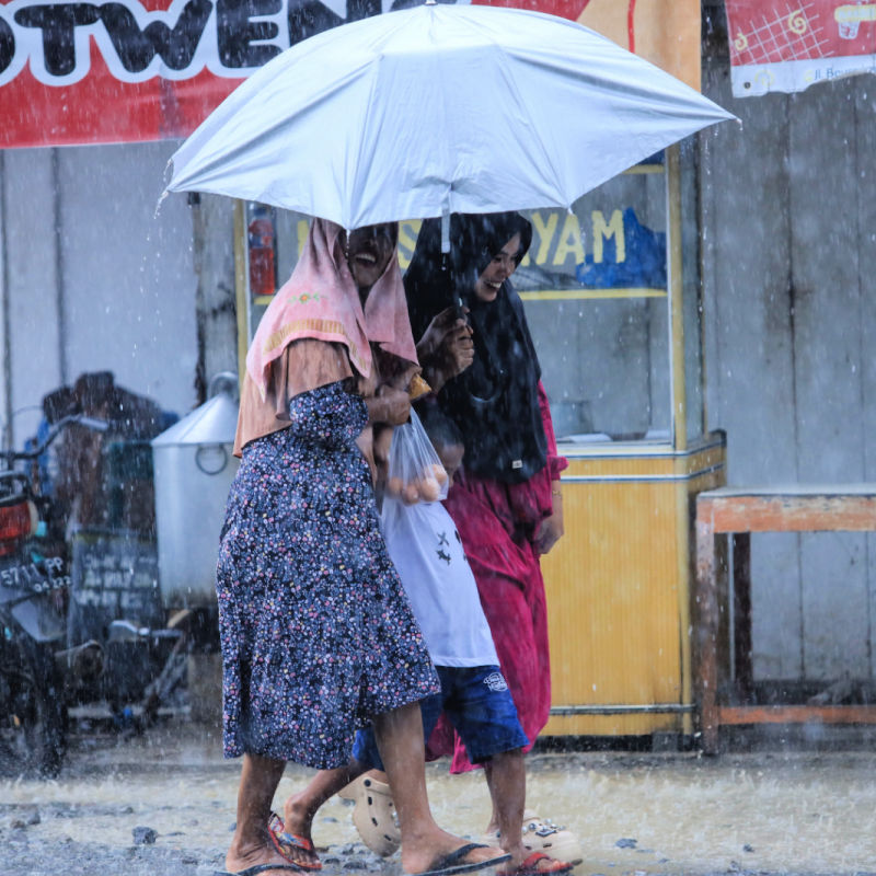Women Walk in Rain in Indonesia Floods