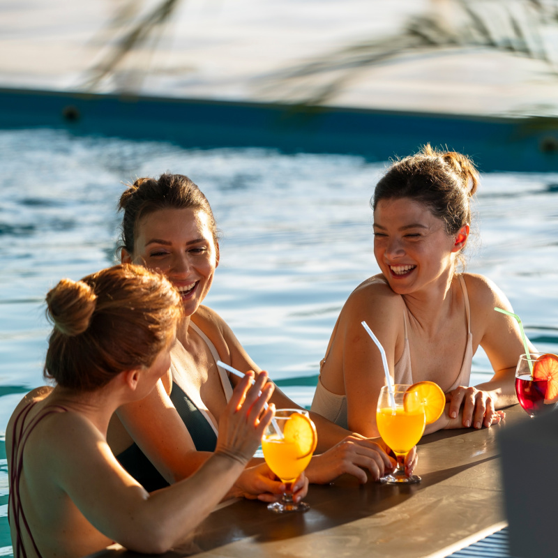 Friends Drink Cocktails in Pool at Beach Club in Bali.jpg