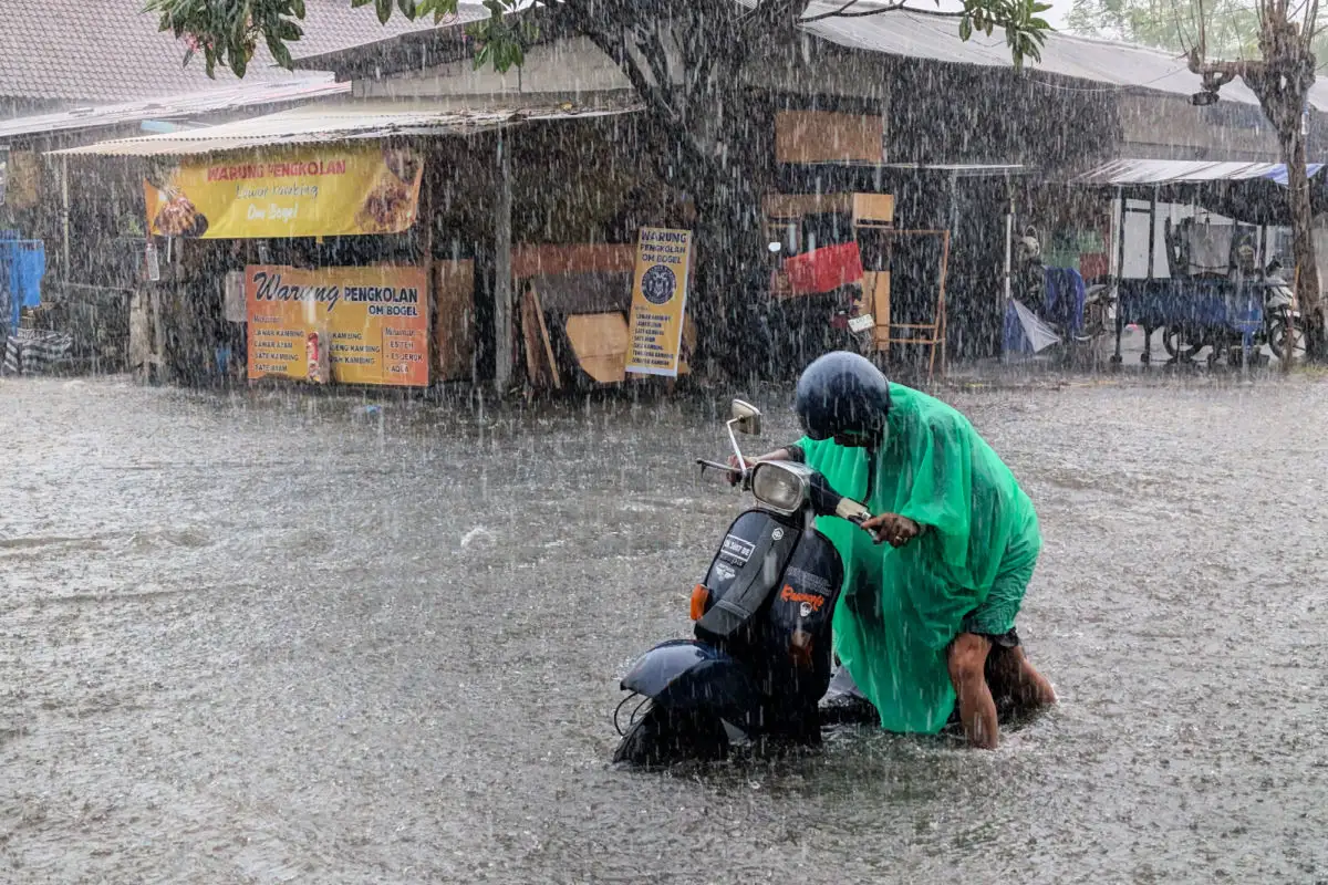Driver Pushes Moped in Rain Flood Storm in Bali