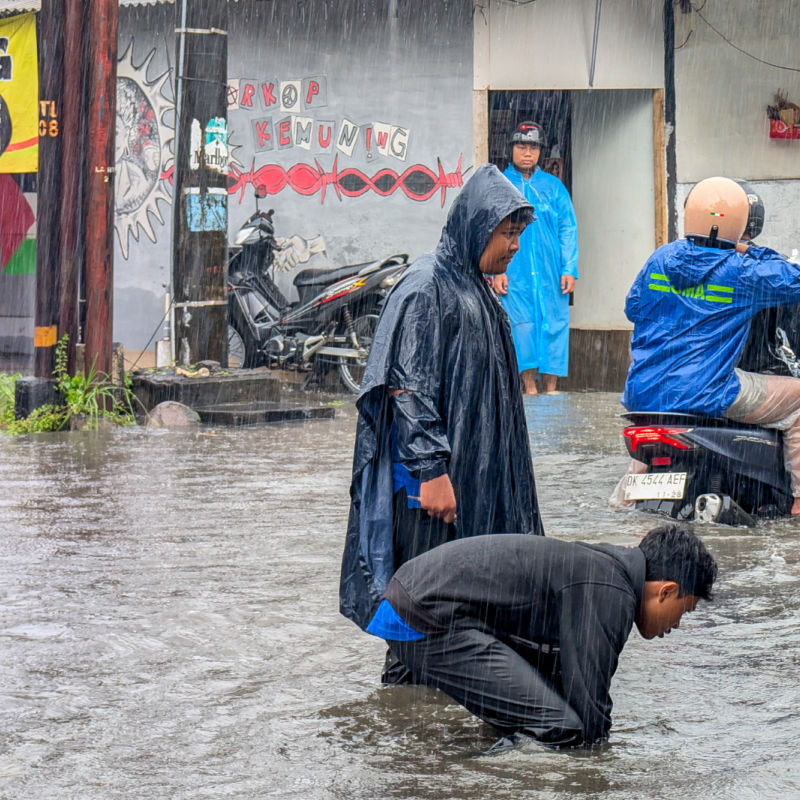 Balinese Men in Flood Water in Bali Storm Extreme Weather Rain.jpg