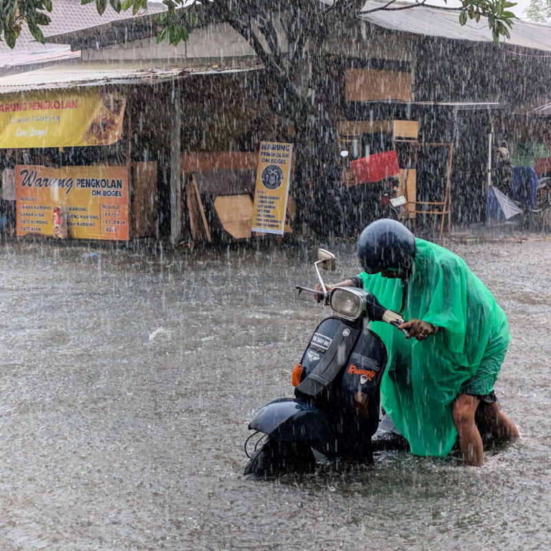 Driver Pushes Moped in Rain Flood Storm in Bali