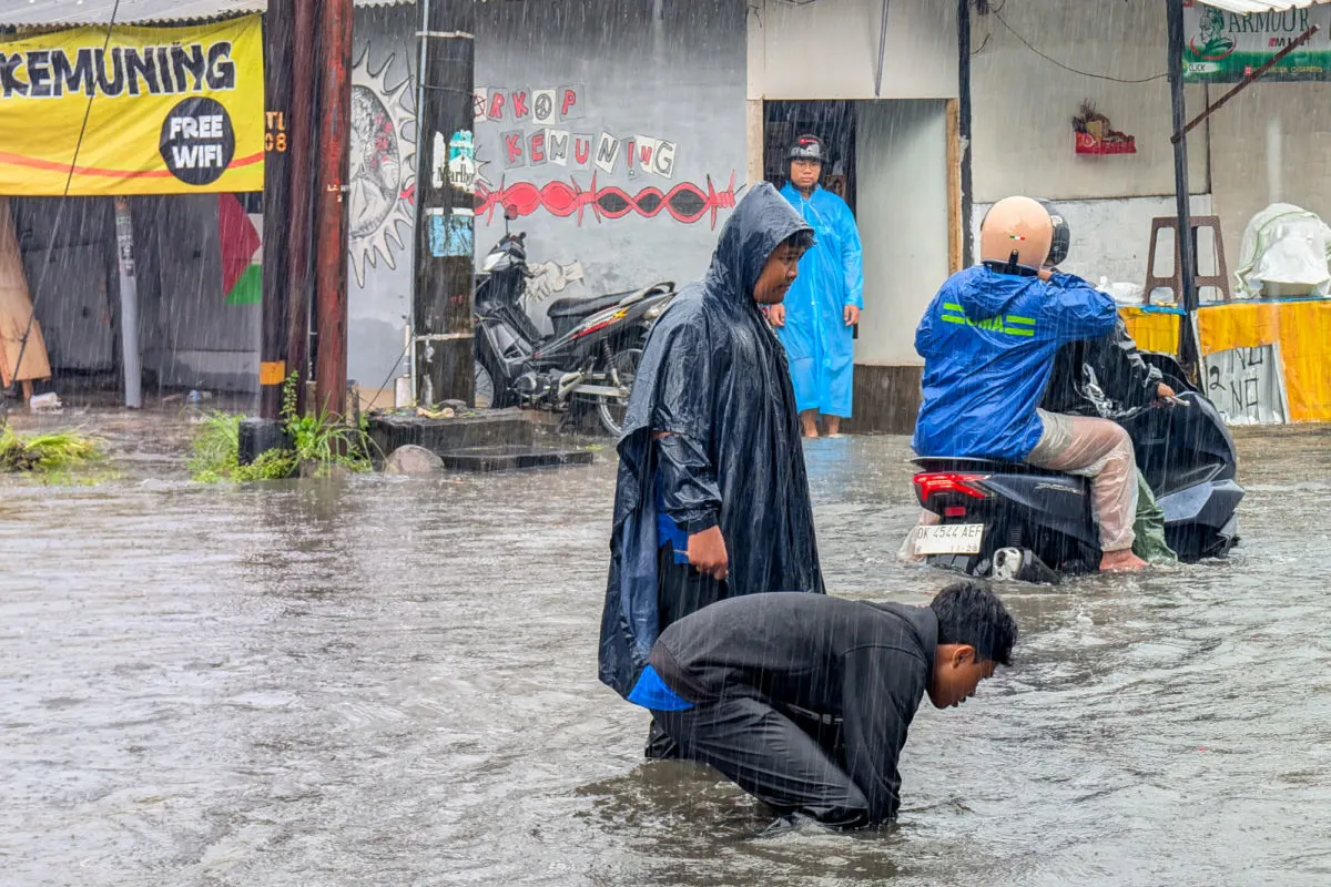 Balinese Men in Flood Water in Bali Storm Extreme Weather Rain.jpg