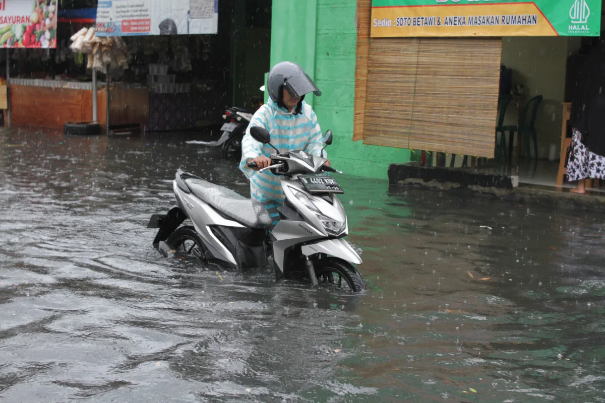 Driver moves Moped In Flood Water in Bali Storm Extreme Weather.jpg
