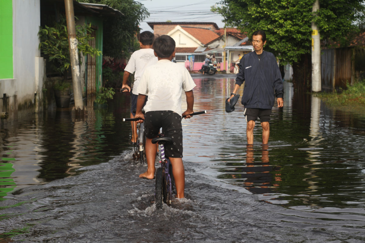 Local People Pass Through Flood Waters in Indonesia.jpg