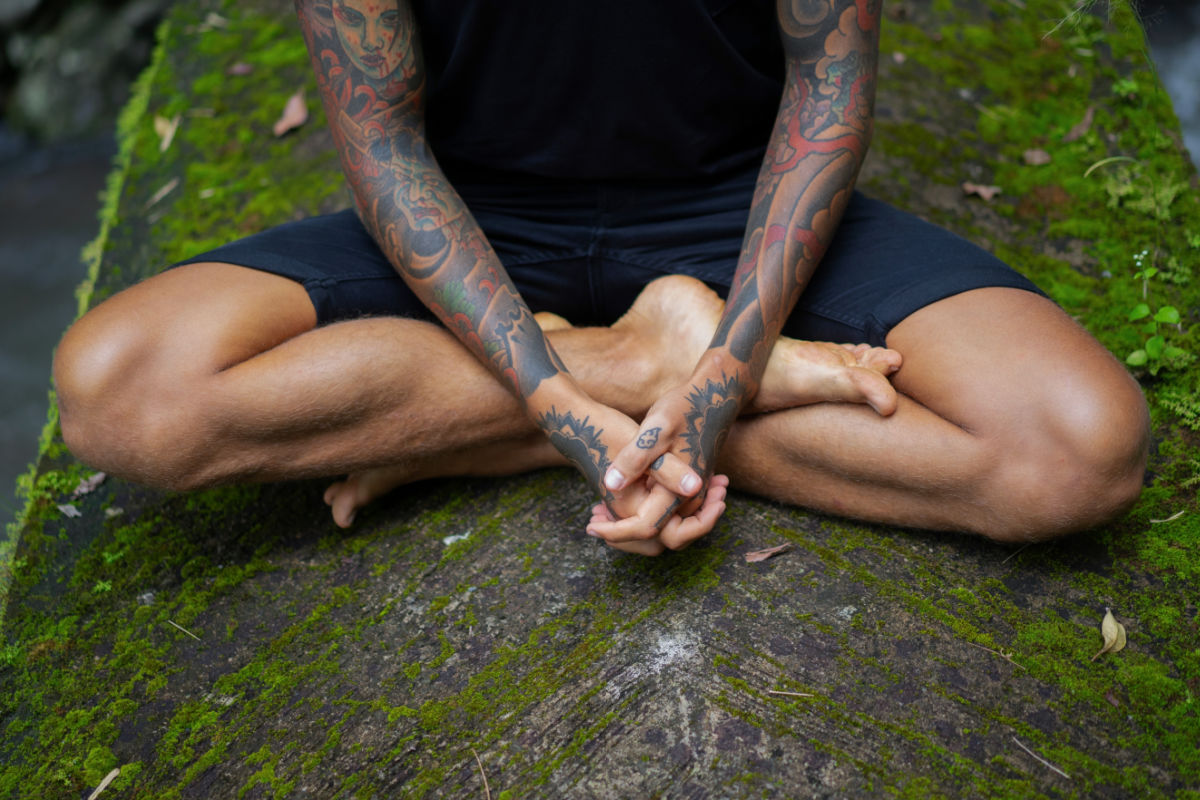 View of Man Cross Legged with Tattoos in Bali Meditation